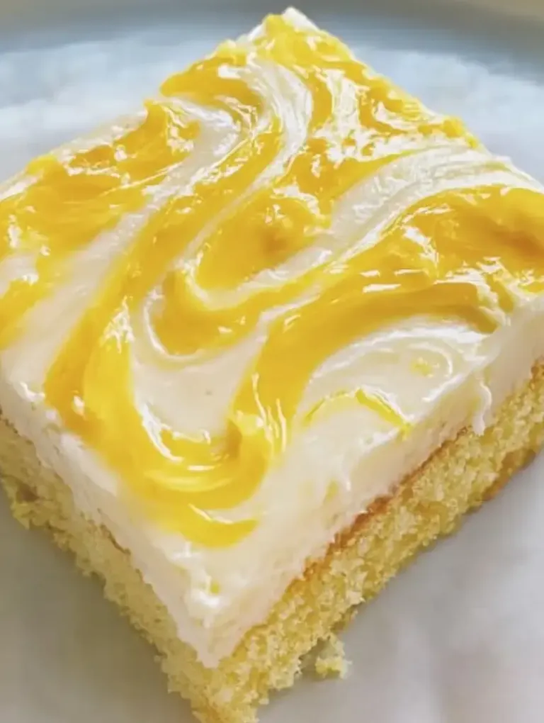 Ein Stück saftiger Kuchen mit einer cremigen, beschichtenden weißen und gelben Glasur.