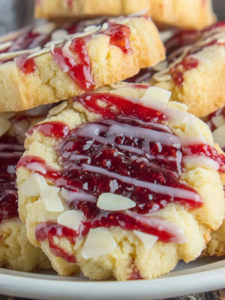 A cookie with white icing and red jam.