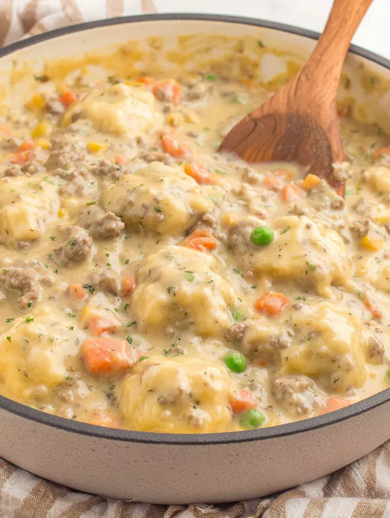 A bowl of ground beef and dumplings.