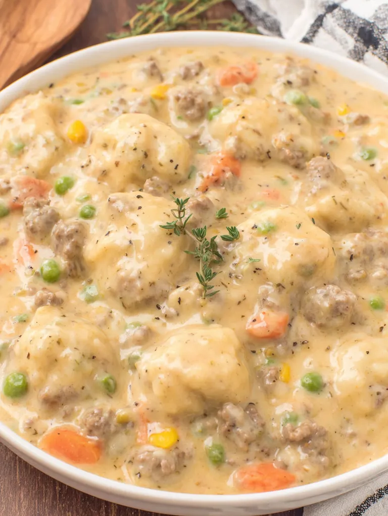 A bowl of ground beef and dumplings.