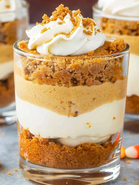 A cup of pumpkin pie with whipped cream on top.