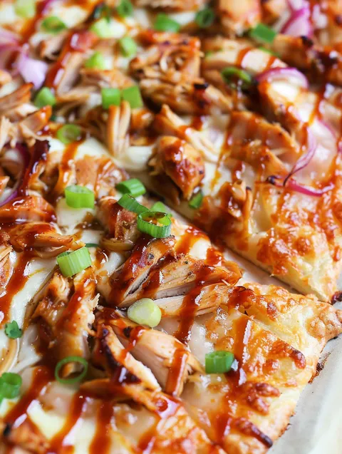 A BBQ chicken pizza with onions and green peppers.