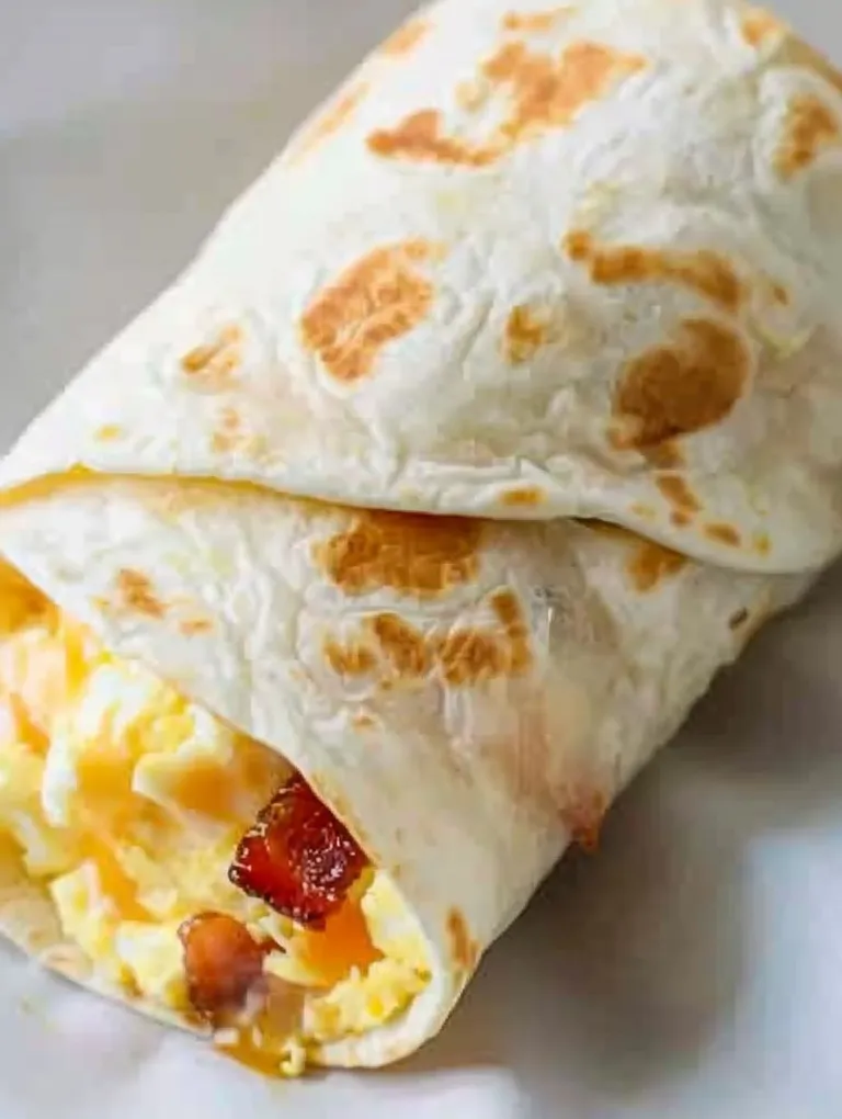A burrito filled with eggs, bacon, and cheese.