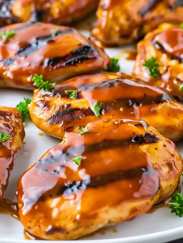 Honey barbecue grilled chicken on a white plate.
