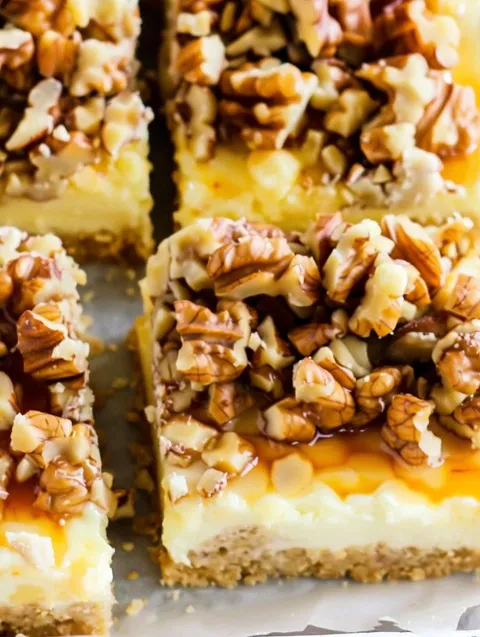 A slice of cake with walnuts on top.